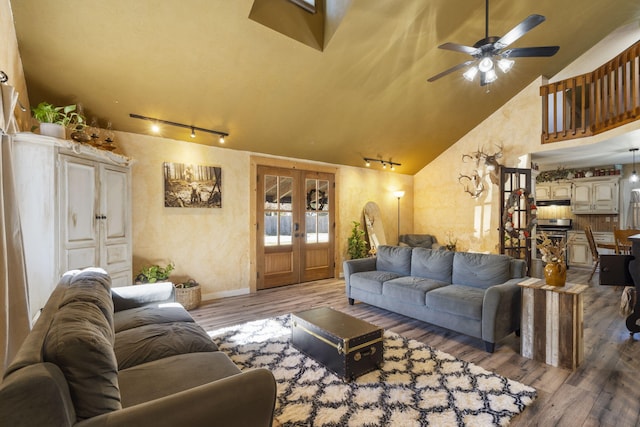 living room featuring track lighting, ceiling fan, high vaulted ceiling, wood-type flooring, and french doors