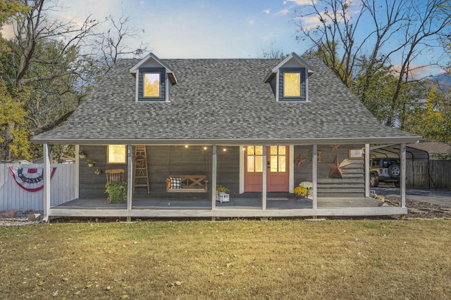 back of property featuring covered porch and a lawn