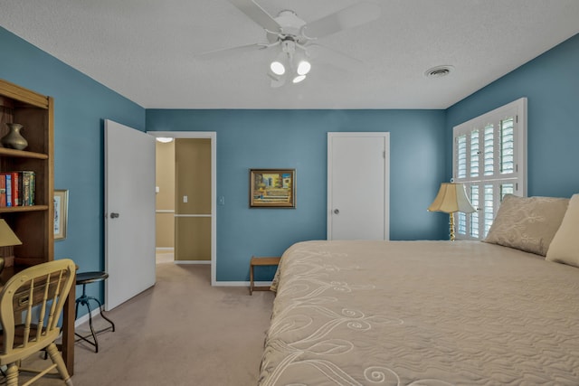 carpeted bedroom featuring a textured ceiling and ceiling fan