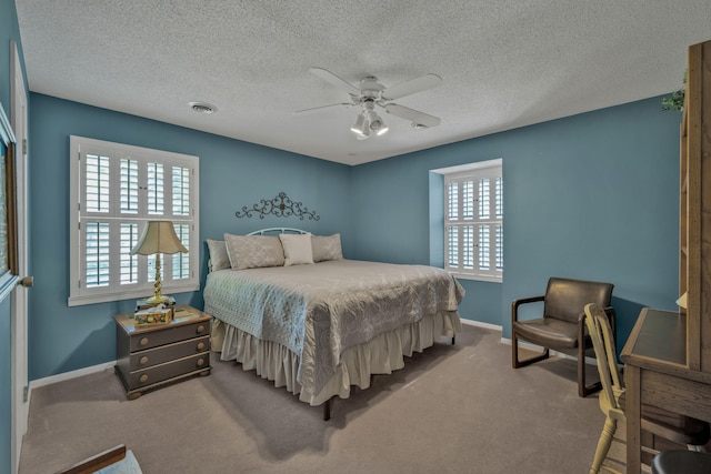 carpeted bedroom featuring ceiling fan and a textured ceiling