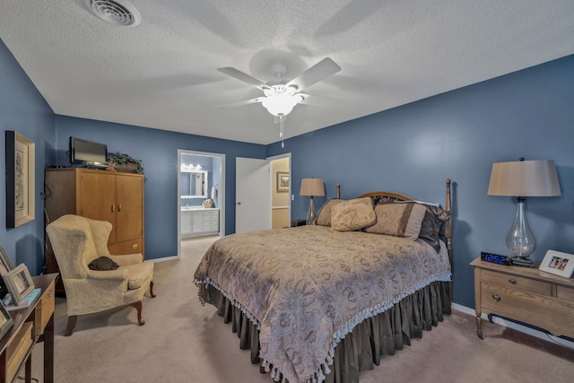 carpeted bedroom featuring a textured ceiling, ensuite bathroom, and ceiling fan