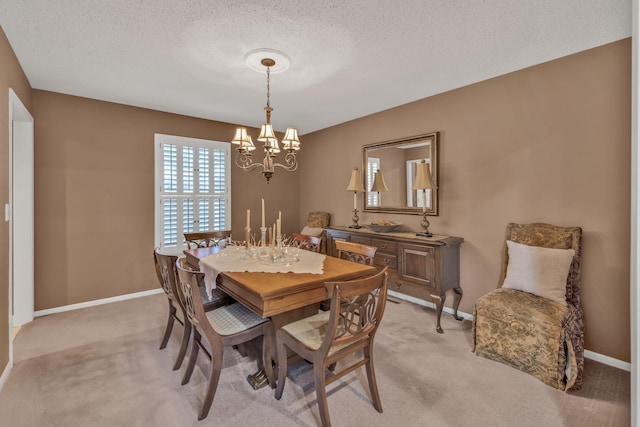 dining space with a textured ceiling, an inviting chandelier, and light colored carpet