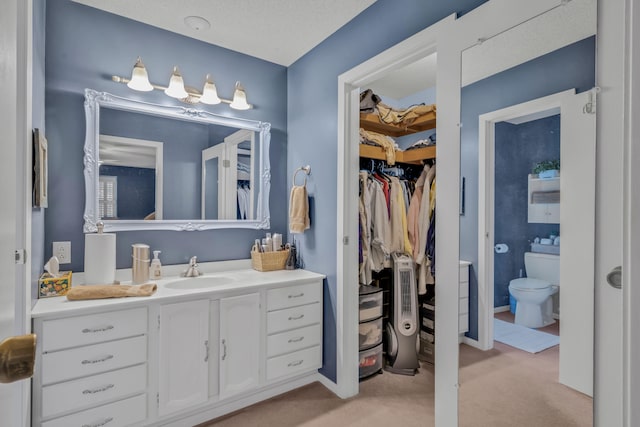 bathroom featuring toilet, a textured ceiling, and vanity