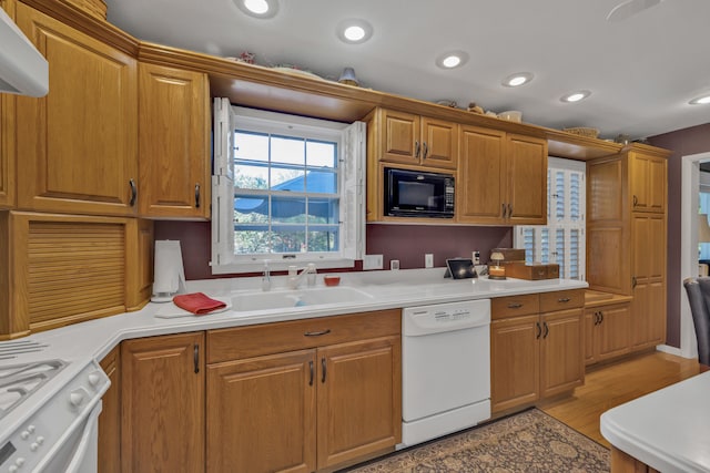 kitchen with white appliances, light hardwood / wood-style floors, and sink