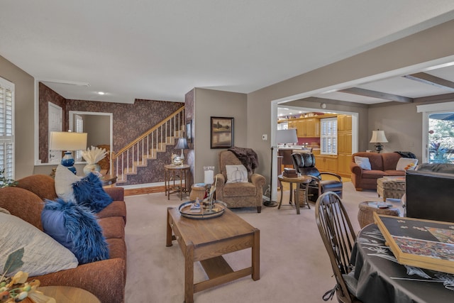 living room featuring beam ceiling and light colored carpet