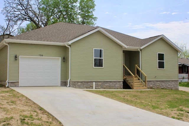 view of front of home with a front lawn, driveway, a garage, and a shingled roof