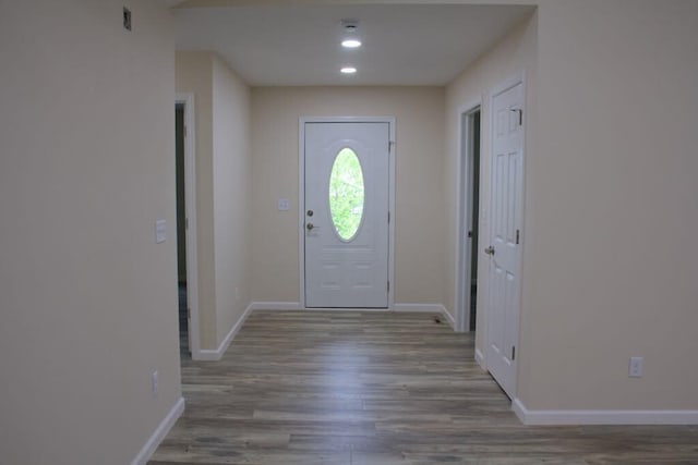 foyer entrance with wood finished floors, recessed lighting, and baseboards