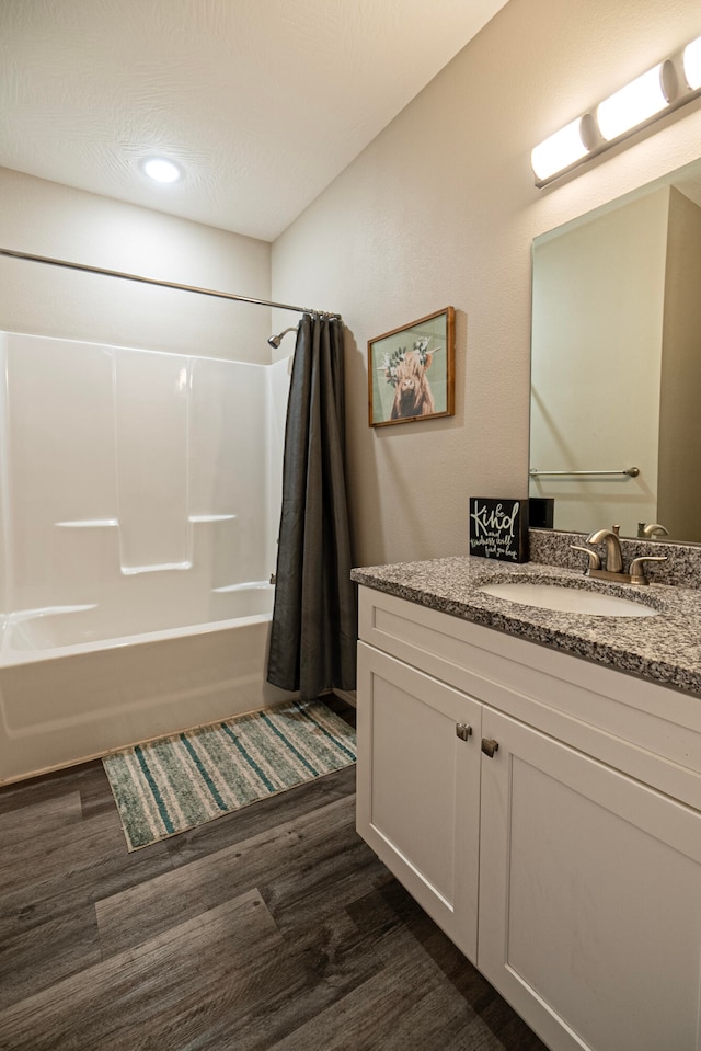 bathroom featuring vanity, a textured ceiling, hardwood / wood-style flooring, and shower / bath combination with curtain