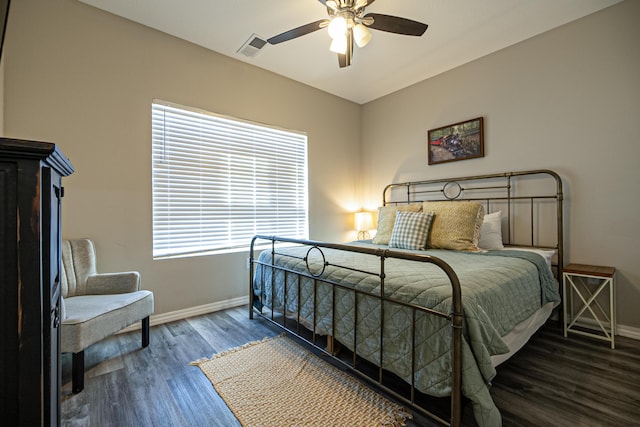 bedroom featuring baseboards, visible vents, a ceiling fan, and wood finished floors