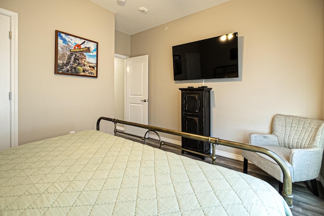 bedroom featuring wood finished floors and baseboards