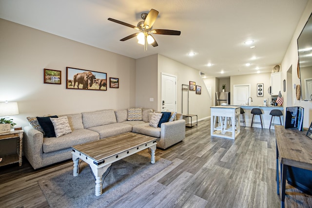 living area with wood finished floors, baseboards, ceiling fan, and recessed lighting