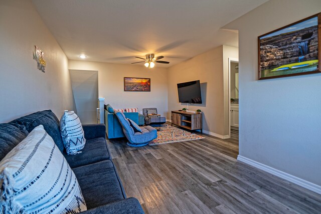 living room featuring ceiling fan and dark hardwood / wood-style floors