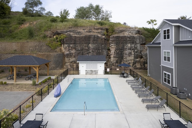 pool with central air condition unit, a patio, fence, and a gazebo