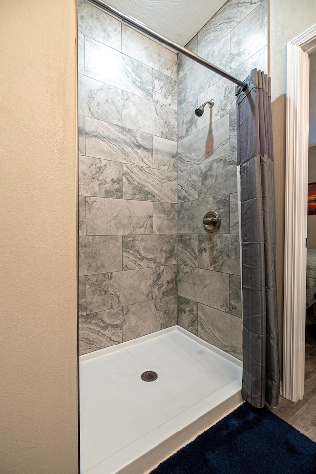 bathroom featuring hardwood / wood-style floors, a textured ceiling, and a shower with shower curtain