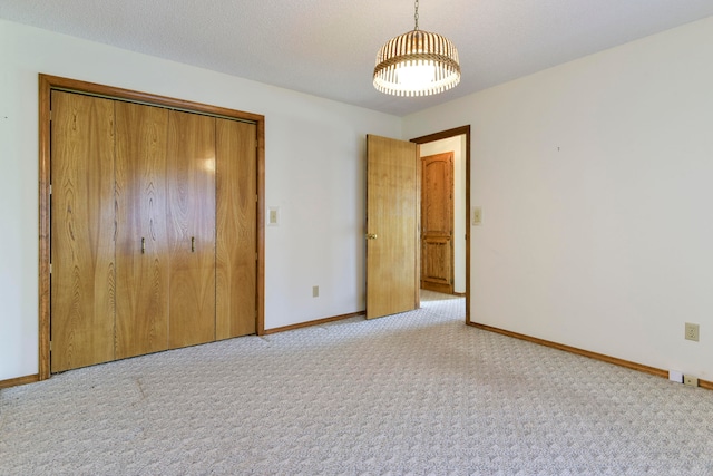 unfurnished bedroom with a closet, light carpet, and a textured ceiling