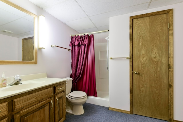 bathroom with vanity, toilet, a drop ceiling, and a shower with shower curtain