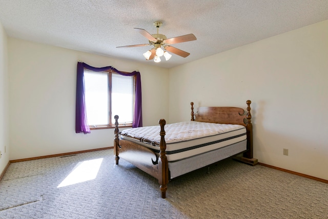 carpeted bedroom with ceiling fan and a textured ceiling