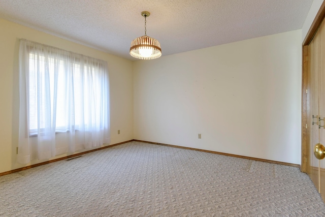 carpeted spare room with a textured ceiling