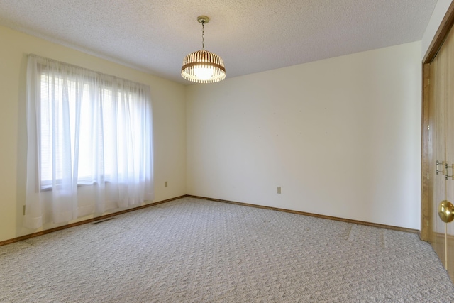 1462 E Powell St, Springfield, MO 65804 - unfurnished room featuring light carpet, a textured ceiling, a chandelier, and baseboards