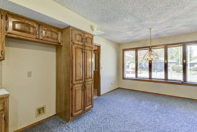 1462 E Powell St, Springfield, MO 65804 - kitchen with a textured ceiling, brown cabinets, carpet, baseboards, and pendant lighting