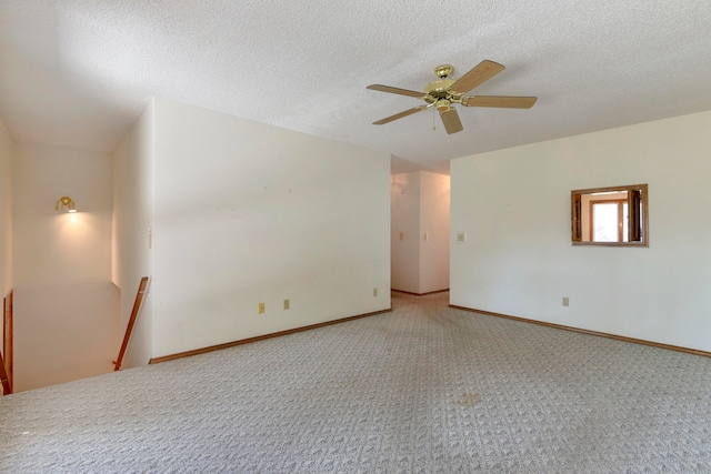 carpeted empty room with a textured ceiling and ceiling fan