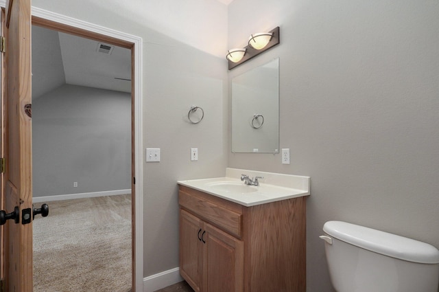 bathroom with vanity, lofted ceiling, and toilet