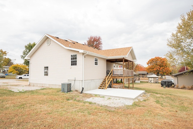 rear view of property with central AC and a yard