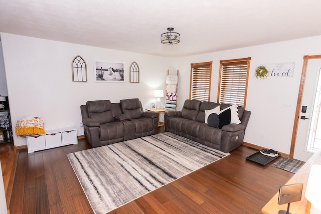 living room with dark wood-type flooring and plenty of natural light