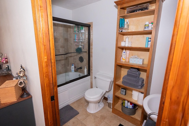 bathroom with shower / bath combination with glass door, toilet, and tile patterned flooring