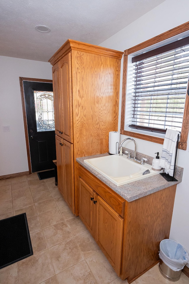 bathroom featuring sink, tile patterned floors, a bath, and a wealth of natural light