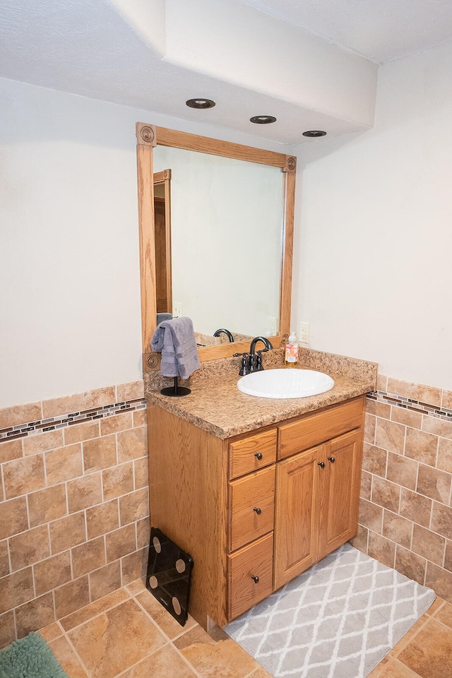 bathroom with vanity and tile walls