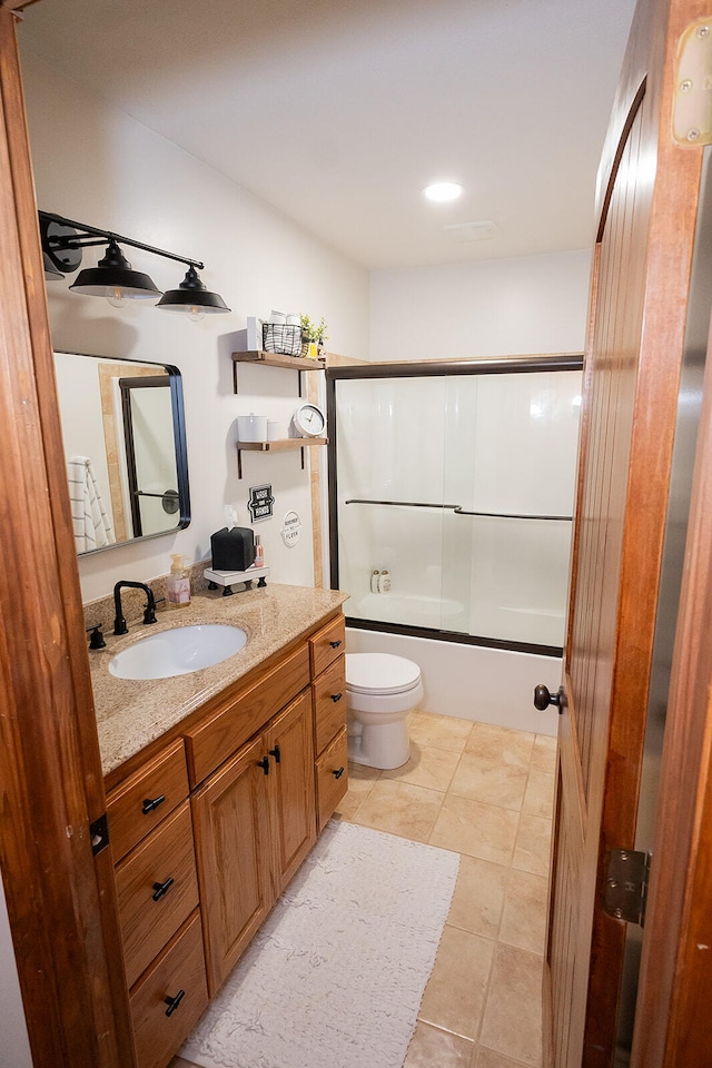 full bathroom featuring vanity, toilet, tile patterned floors, and bath / shower combo with glass door