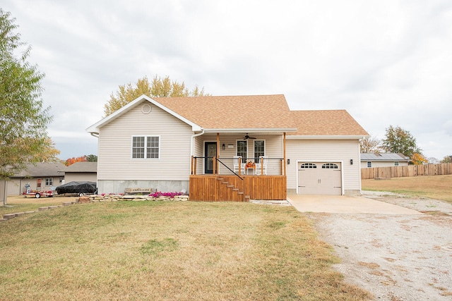 view of front of property with covered porch, a front yard, and a garage