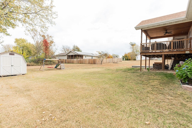 view of yard with a shed, a playground, a deck, and ceiling fan