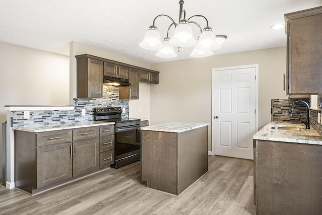 kitchen with hardwood / wood-style flooring, hanging light fixtures, sink, electric range, and light stone counters