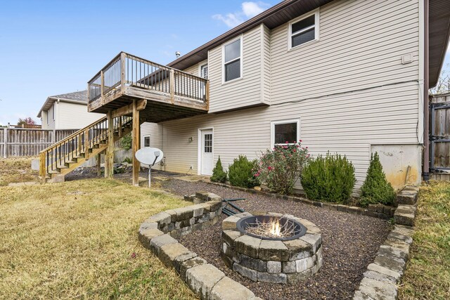 back of house with a deck, an outdoor fire pit, a yard, stairway, and fence