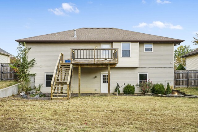 rear view of house featuring fence, a lawn, stairs, and a wooden deck