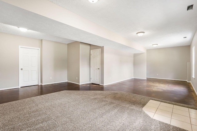 empty room featuring a textured ceiling and dark hardwood / wood-style floors