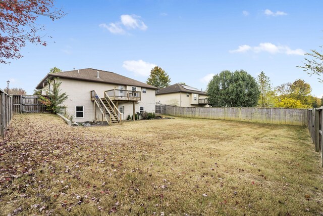 back of house featuring a lawn, stairway, a deck, and a fenced backyard
