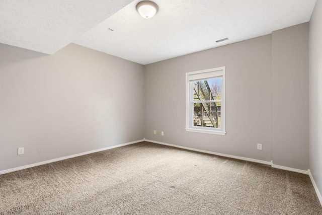 carpeted spare room featuring a textured ceiling