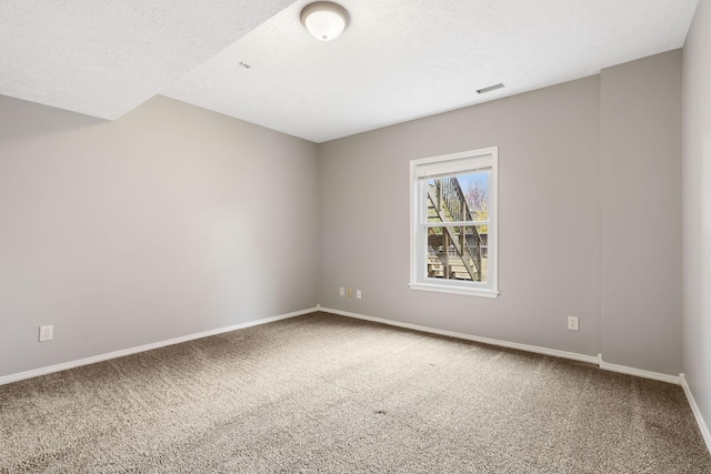 unfurnished room with carpet, a textured ceiling, and baseboards