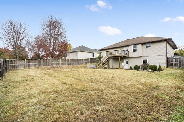 view of yard with a wooden deck, stairway, and a fenced backyard