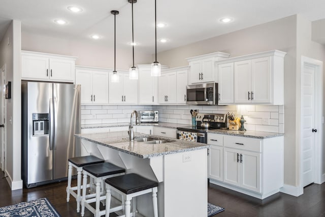 kitchen featuring sink, appliances with stainless steel finishes, white cabinetry, and an island with sink