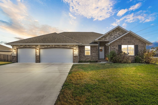 view of front of home with a garage and a lawn