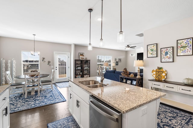 kitchen with sink, stainless steel dishwasher, white cabinets, light stone counters, and dark hardwood / wood-style floors