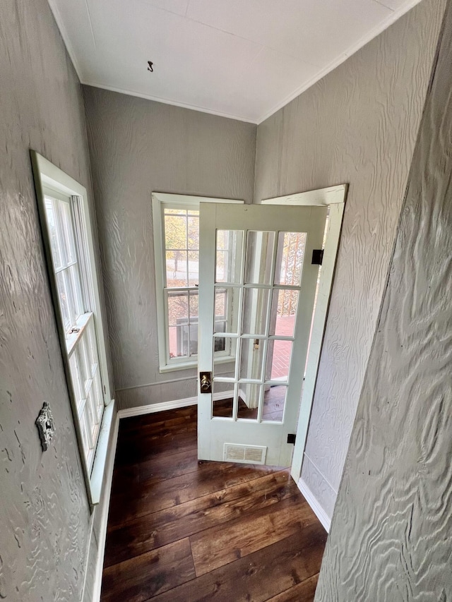 doorway to outside with ornamental molding, hardwood / wood-style floors, and visible vents