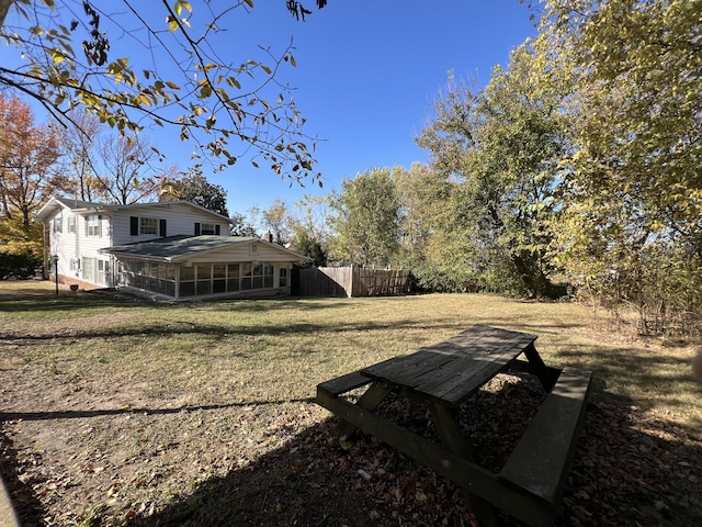 view of yard featuring a sunroom and fence
