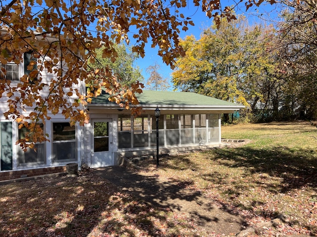 exterior space with a sunroom and a lawn