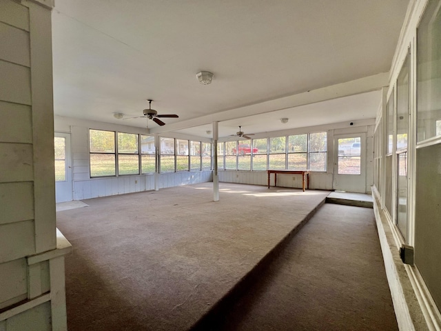 unfurnished sunroom with ceiling fan