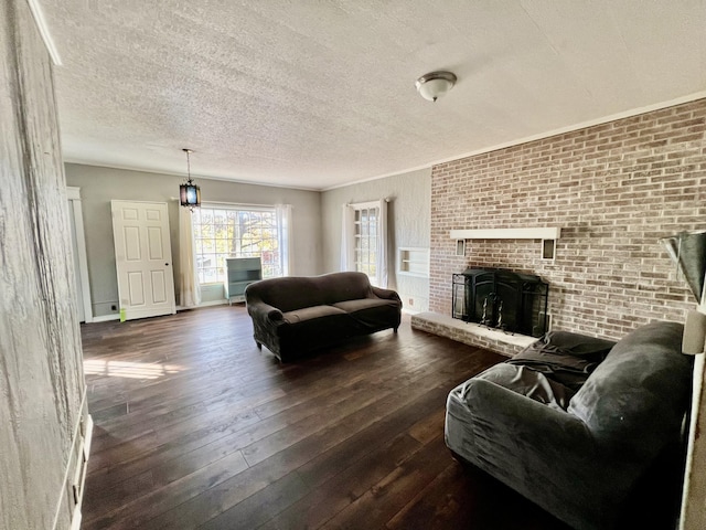 living room featuring a textured ceiling, dark wood-type flooring, and a brick fireplace